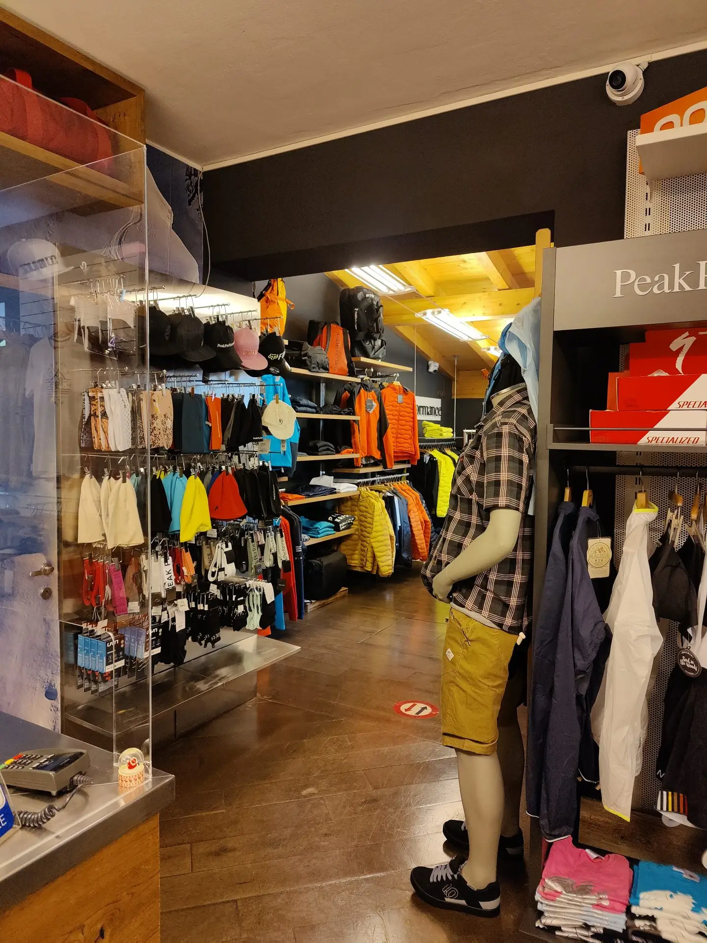 Interno del negozio, corridoio dell’abbigliamento con l’insegna Peak Performance e un manichino