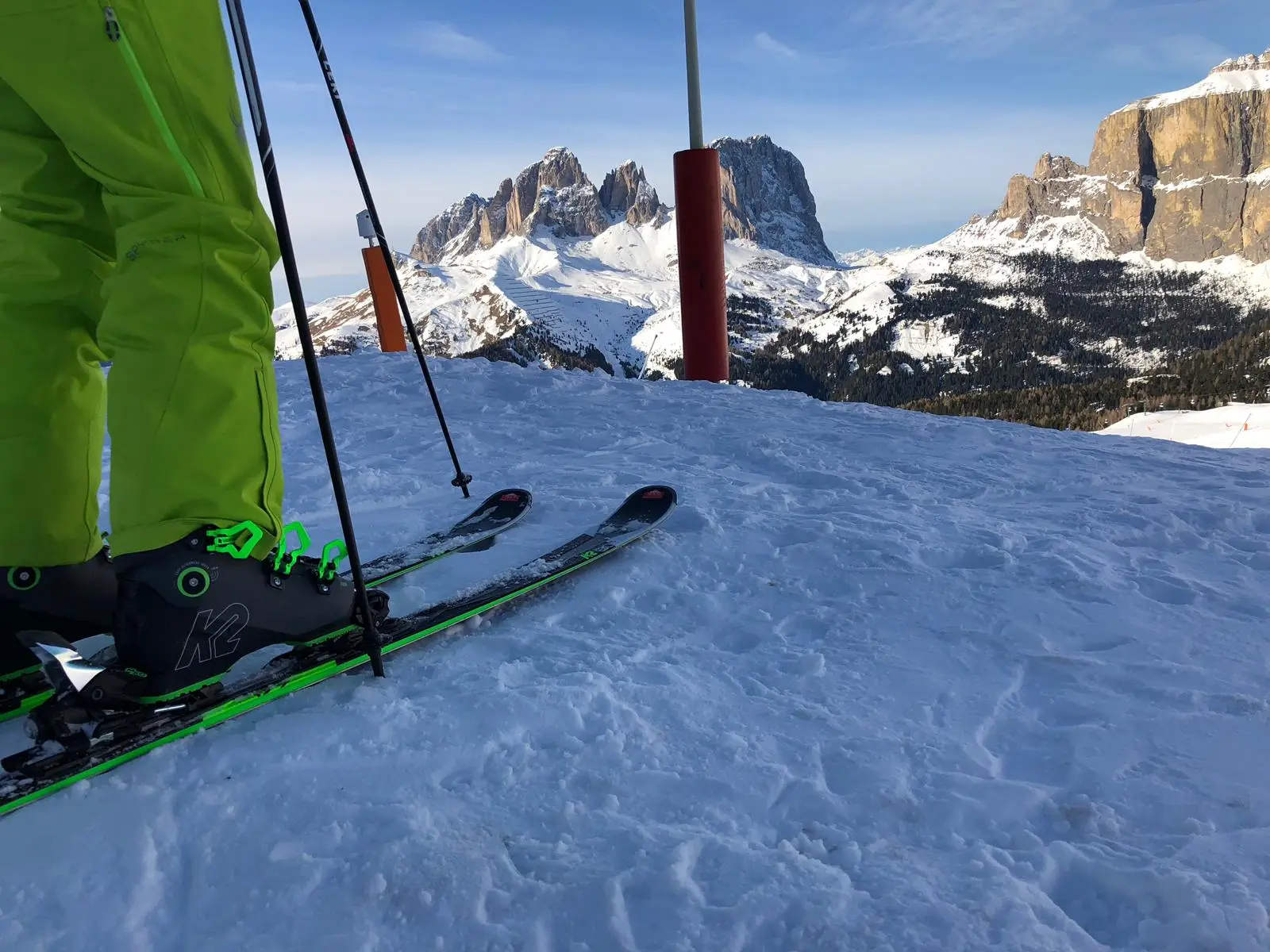 Sci verdi e scarponi K2 visti dall’alto, con Sassolungo e Gruppo del Sella davanti