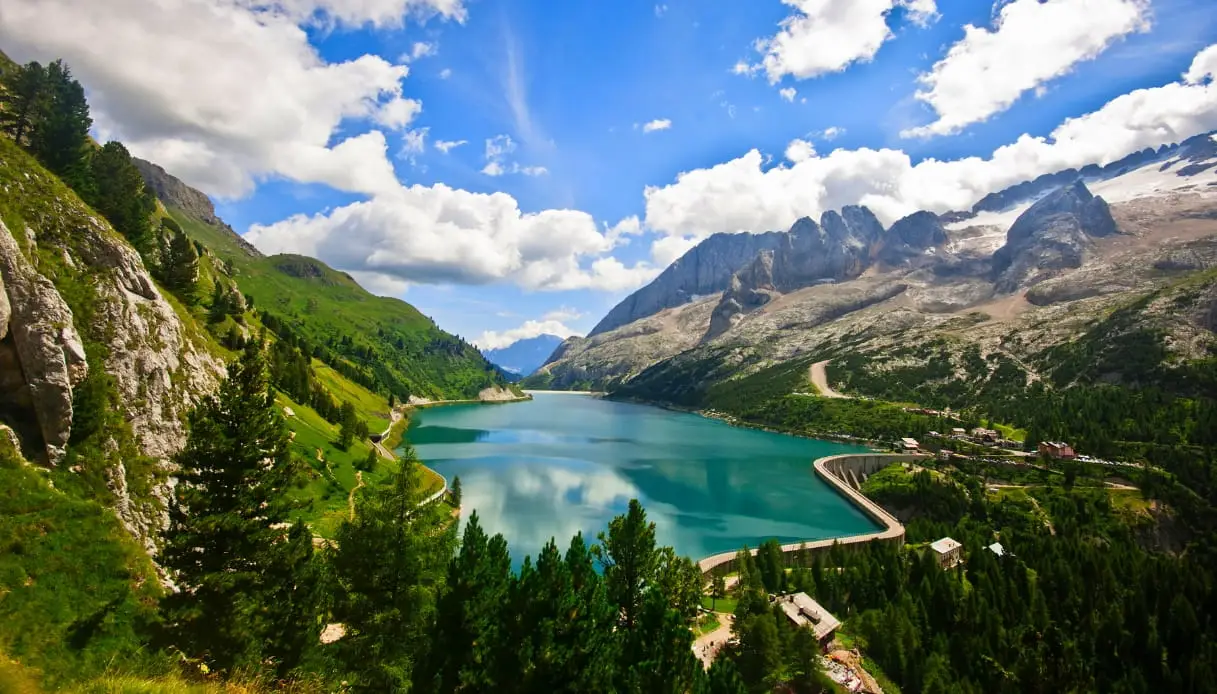 Il Lago di Fedaia turchese in estate con la Marmolada e la valle verde