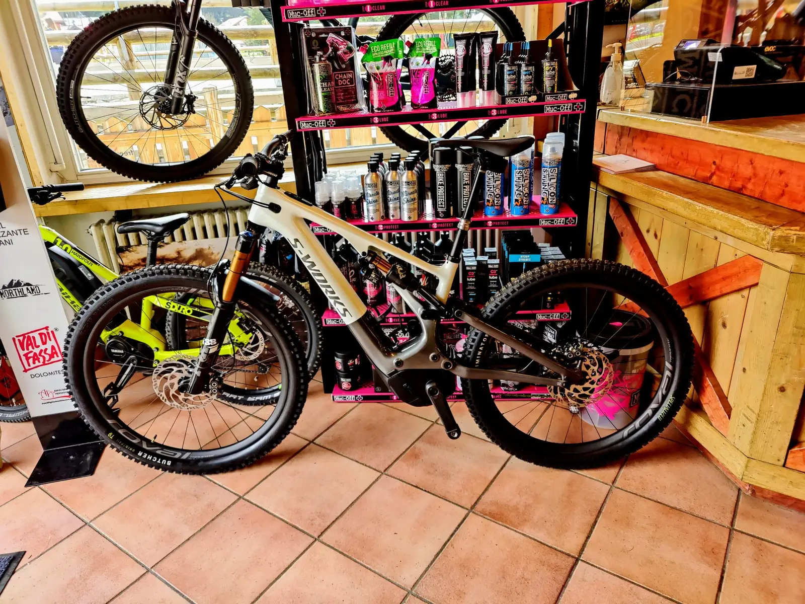 Shop interior: e-MTBs in front of a shelf of bike-care products