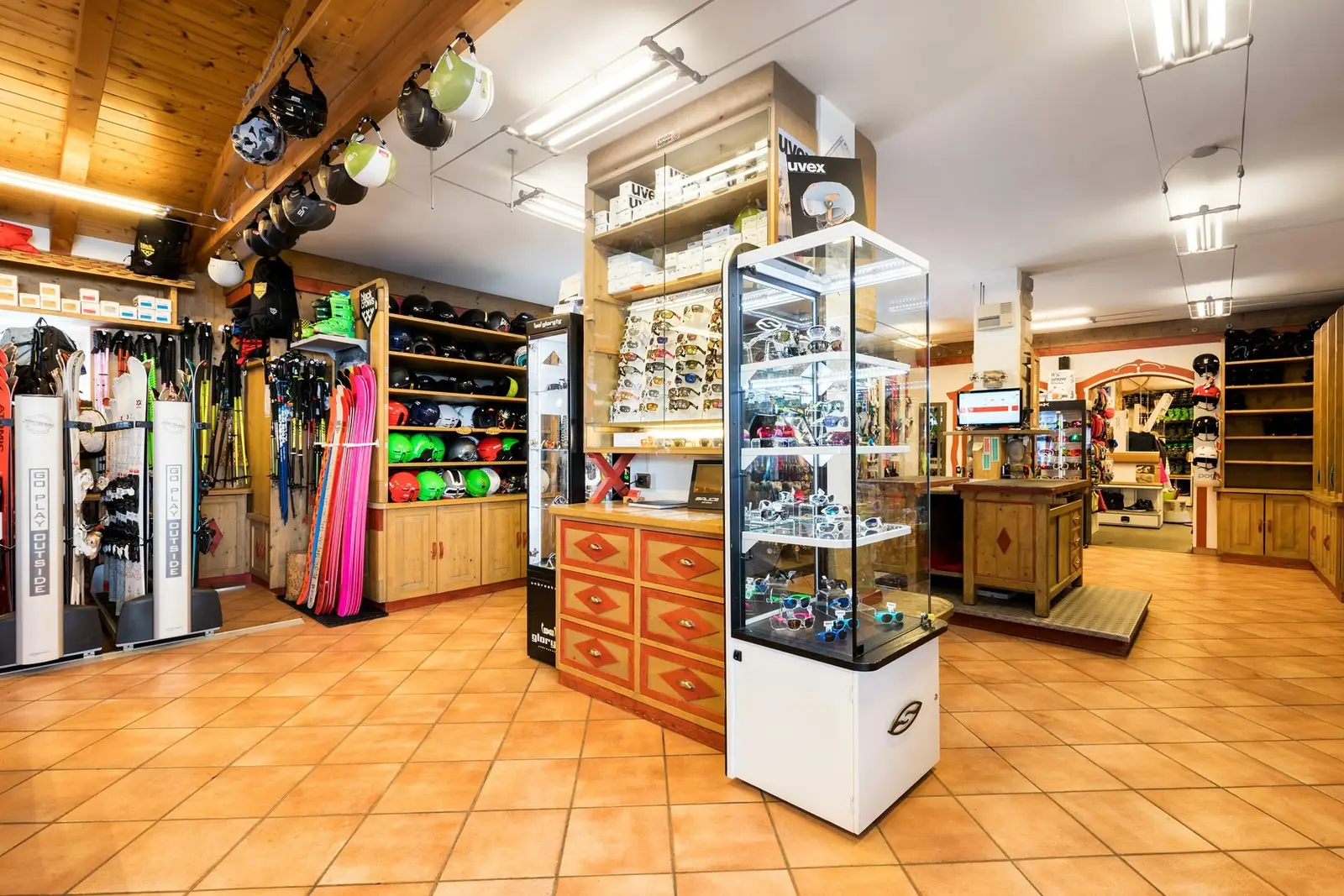 Shop interior: ski boot wall, glass display cases and terracotta floor