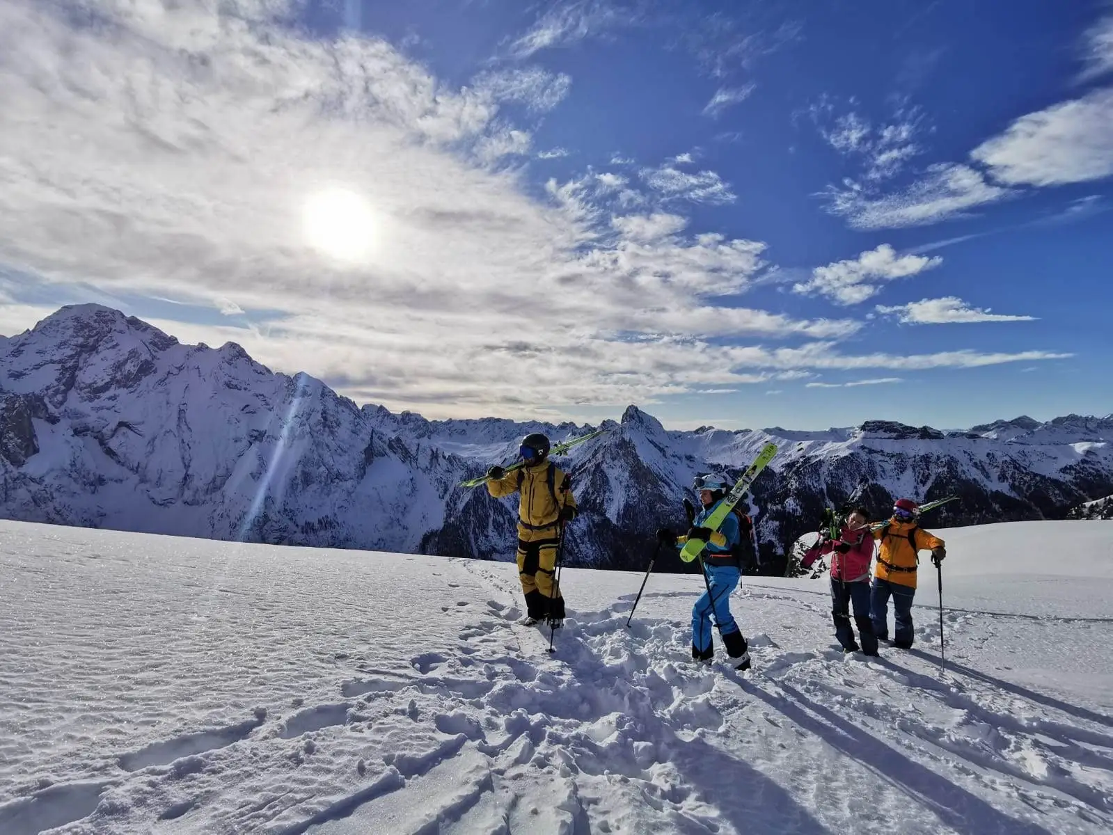 Gruppo di scialpinisti in cresta con gli sci in spalla